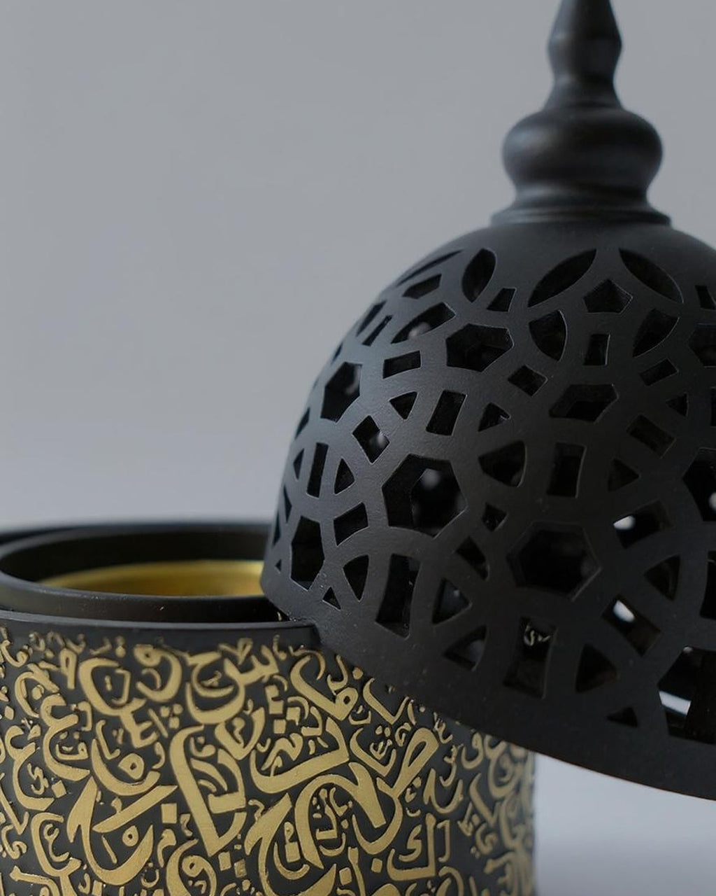 ZYVORA Noor — gold calligraphy and dome latticework, in cool macro detail.